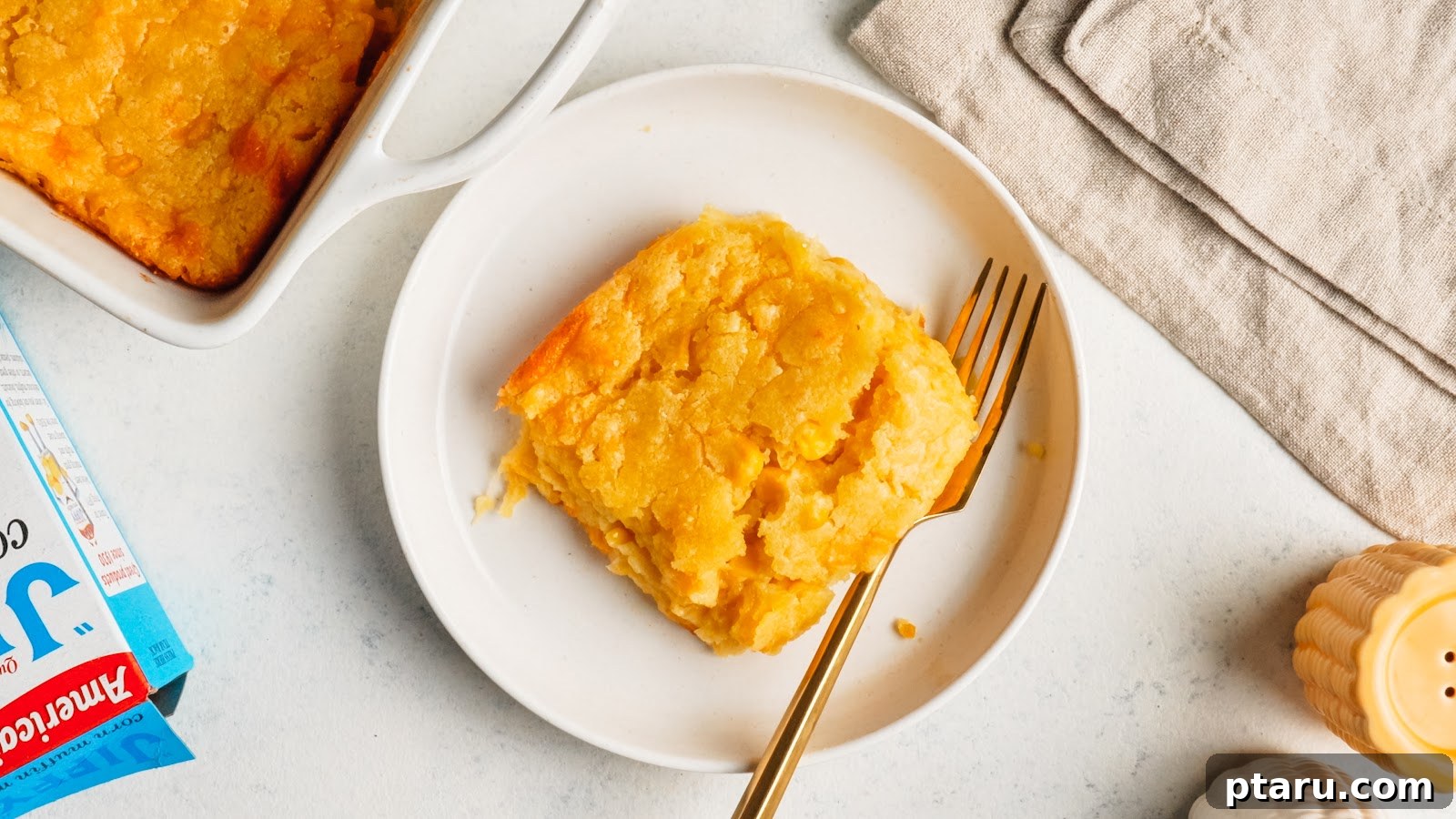Creamy Jiffy Corn Casserole Recipe: Soft & Comforting 11 A square of corn casserole on a white plate with a fork