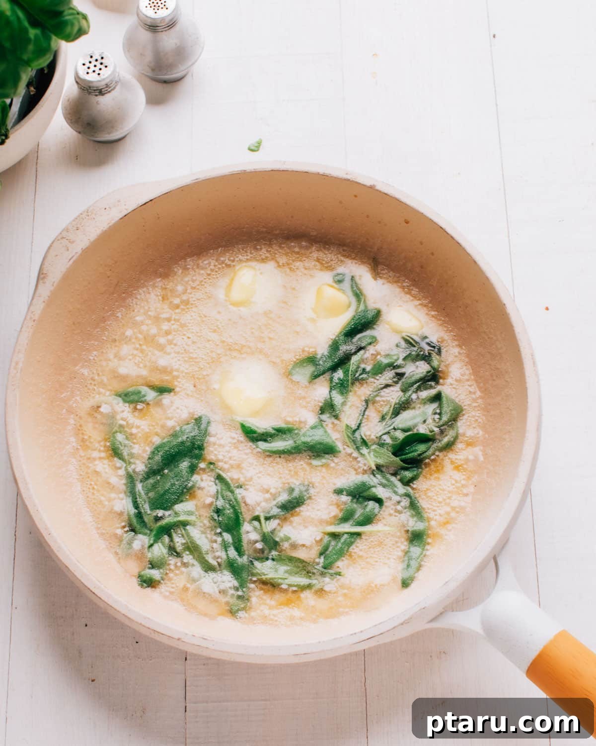 Pumpkin Ravioli Sauce: Brown Butter and Sage 5 Butter and fresh sage leaves foaming in a cream saucepan before the butter browns.