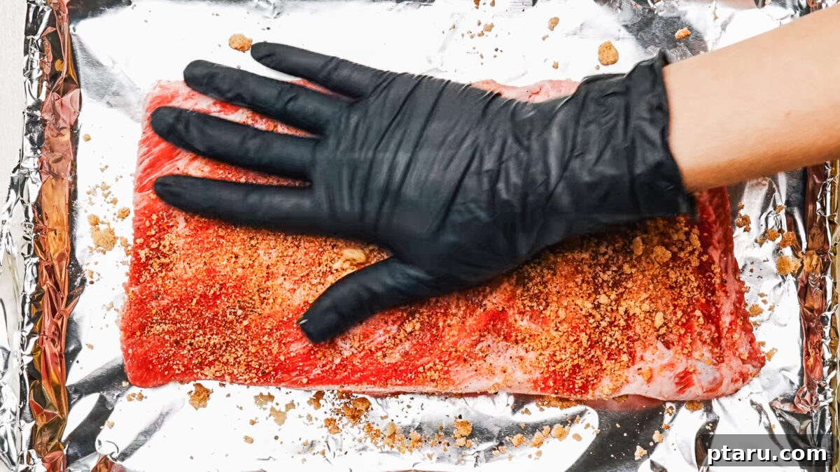 Sweet Dry Rub for Ribs: Flavorful BBQ Seasoning 7 Rubbed ribs on a foil-lined baking sheet ready for the oven.