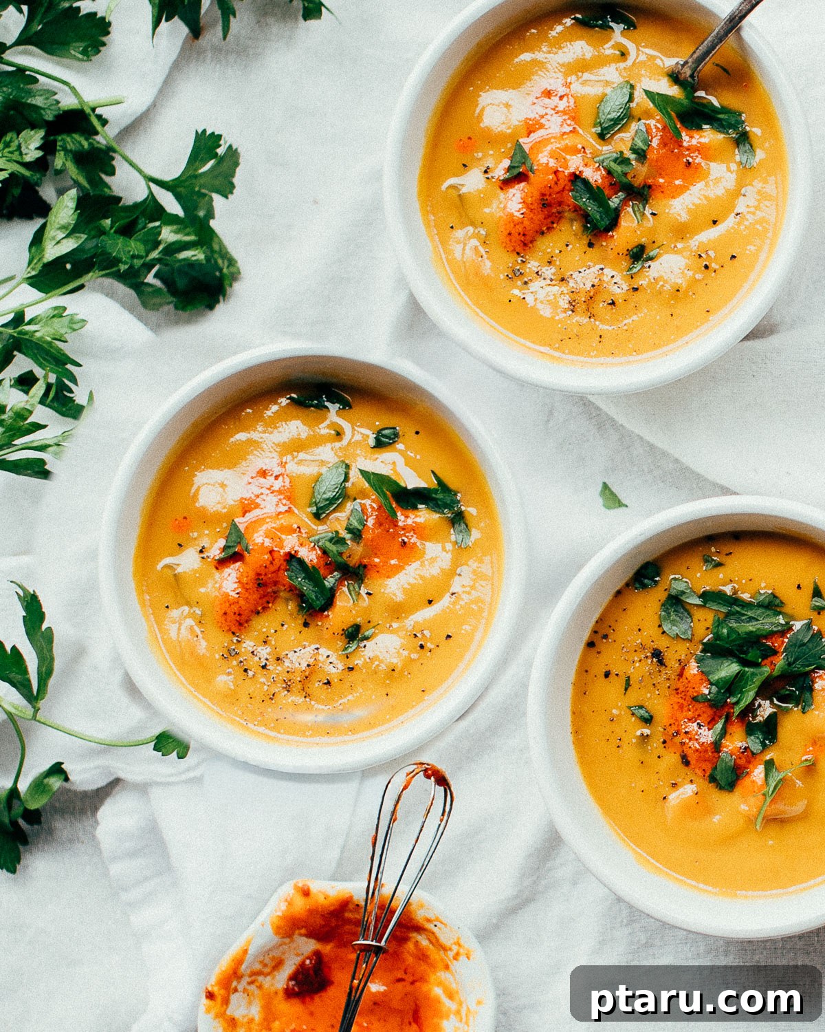 30 Make-Ahead Thanksgiving Side Dishes Your Guests Will Love 27 A bowl of smooth spiced carrot ginger soup garnished with herbs.
