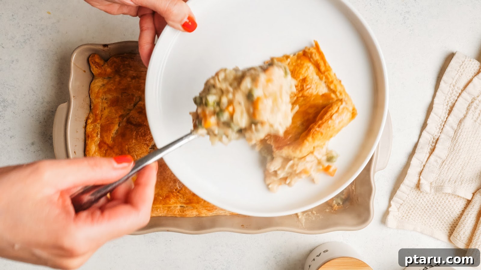Creamy Chicken Pot Pie Casserole with Flaky Puff Pastry 14 A spoonful of creamy chicken and pea filling lifted from the casserole.