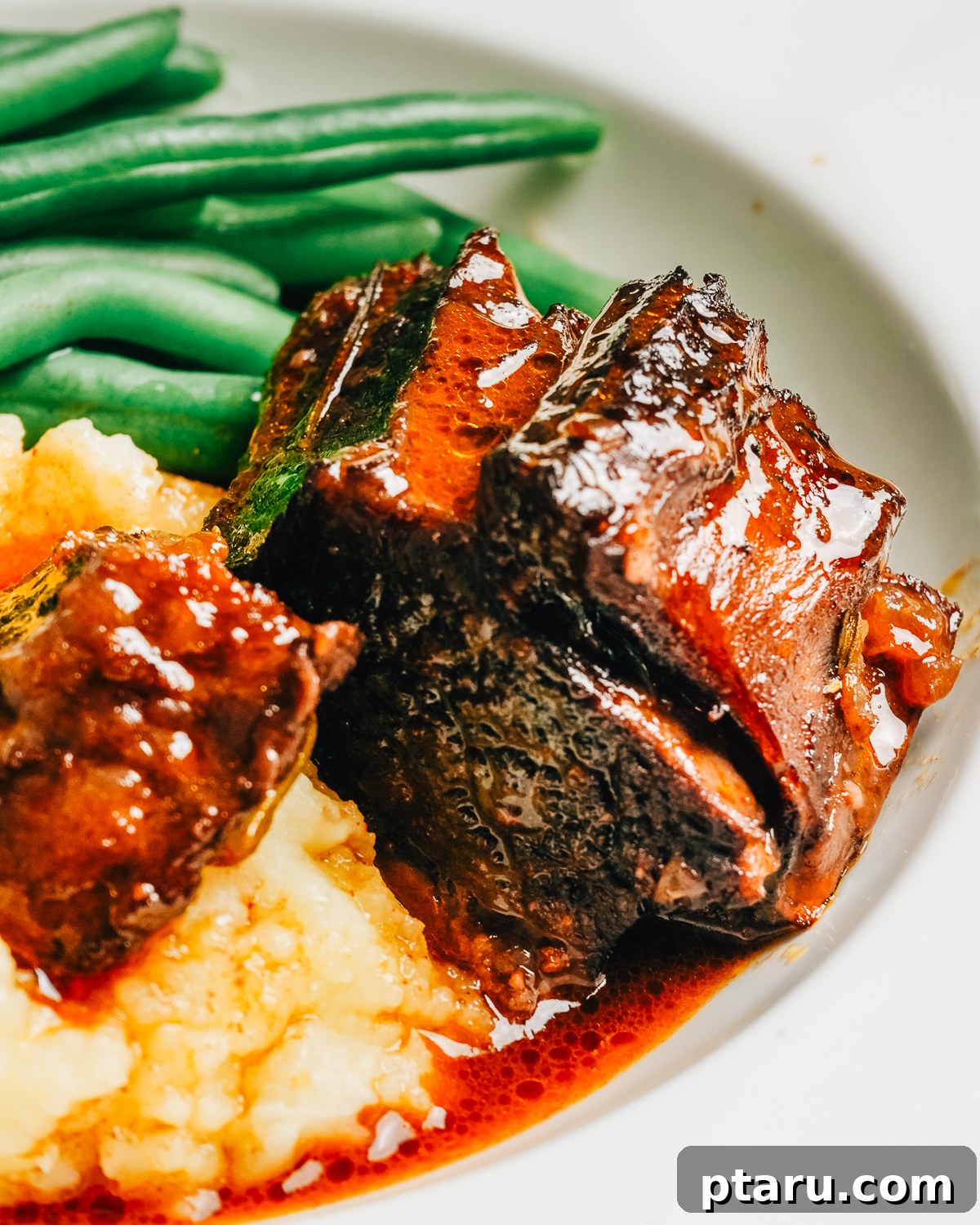 Red Wine-Braised Beef Short Ribs That Fall Apart 2 Close-up of red wine braised beef short ribs over mashed potatoes.