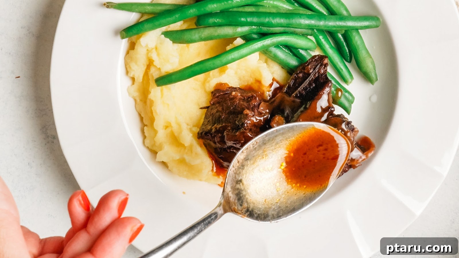Red Wine-Braised Beef Short Ribs That Fall Apart 11 Spooning glossy red wine sauce over braised short ribs and mashed potatoes.