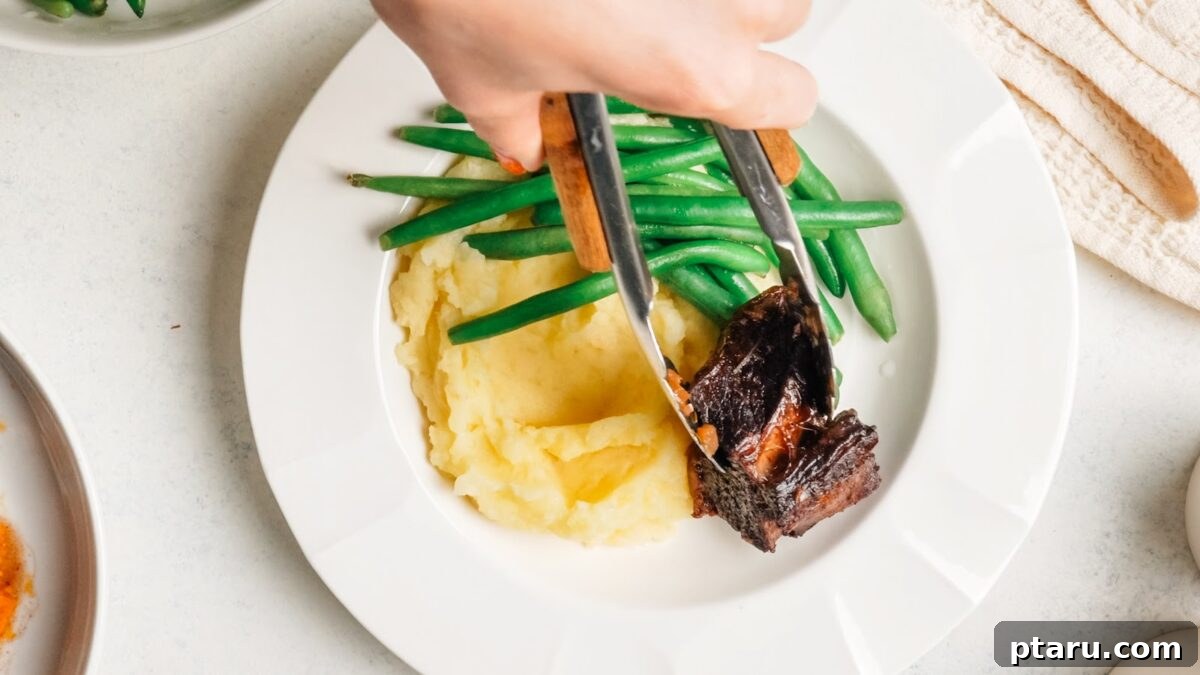 Red Wine-Braised Beef Short Ribs That Fall Apart 10 A dinner plate of braised beef short ribs with mashed potatoes and green beans.