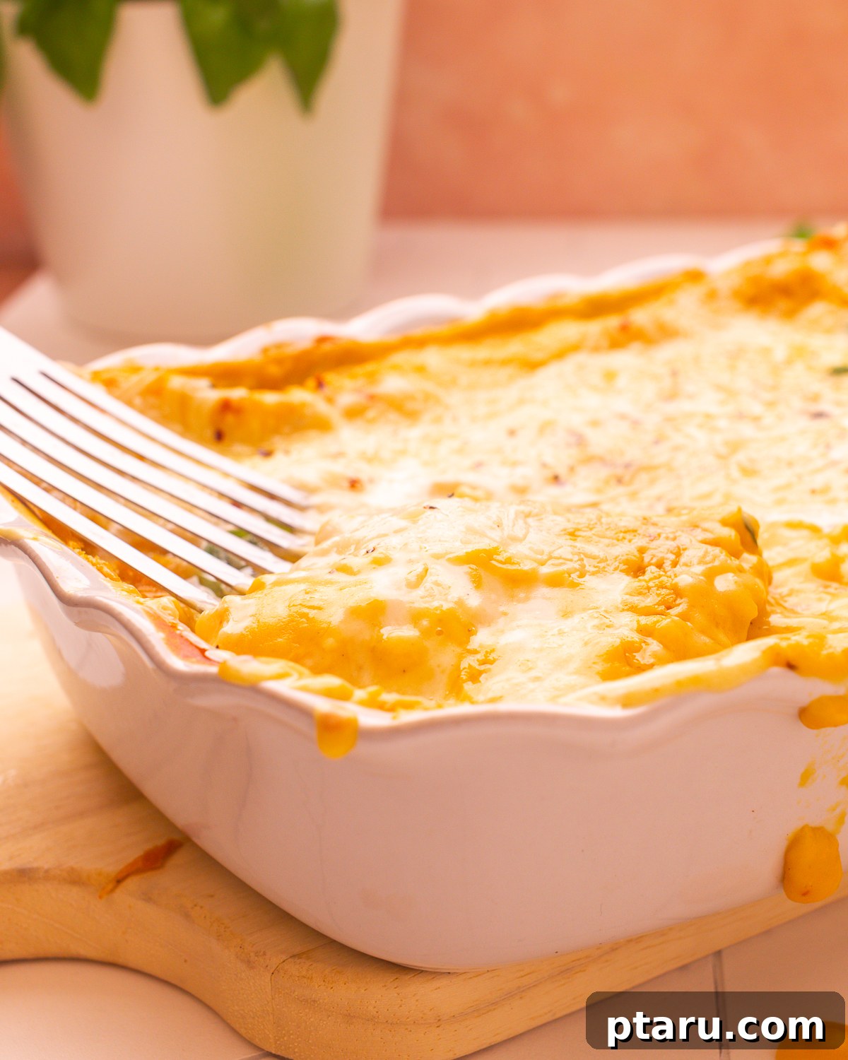 Butternut Squash Lasagna with Creamy Béchamel 4 A fork lifting a creamy bite of butternut squash lasagna from the baking dish.