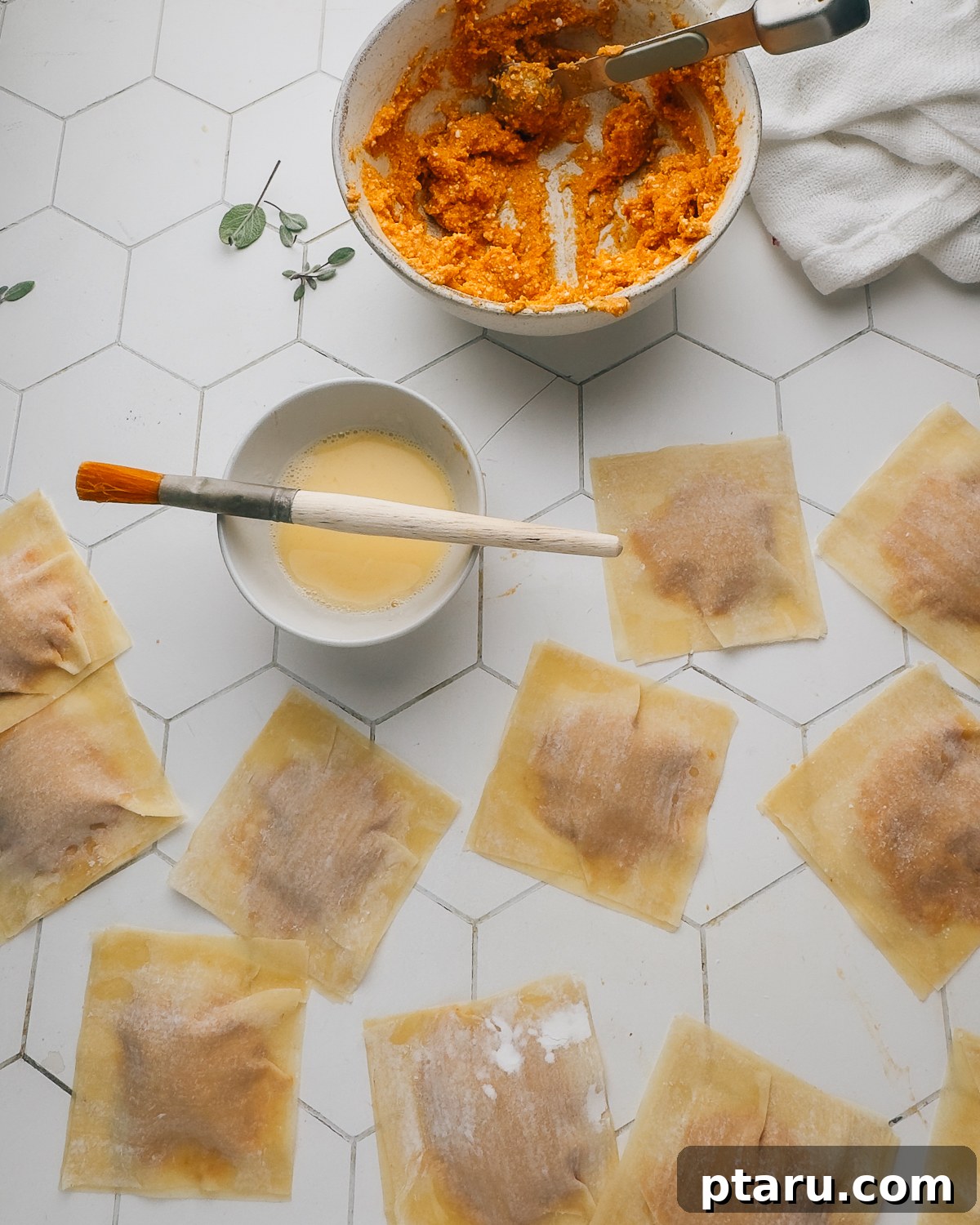 Homemade Pumpkin Ravioli Made with Wonton Wrappers 11 Filled wonton wrapper ravioli with a bowl of egg wash, a pastry brush and pumpkin filling.