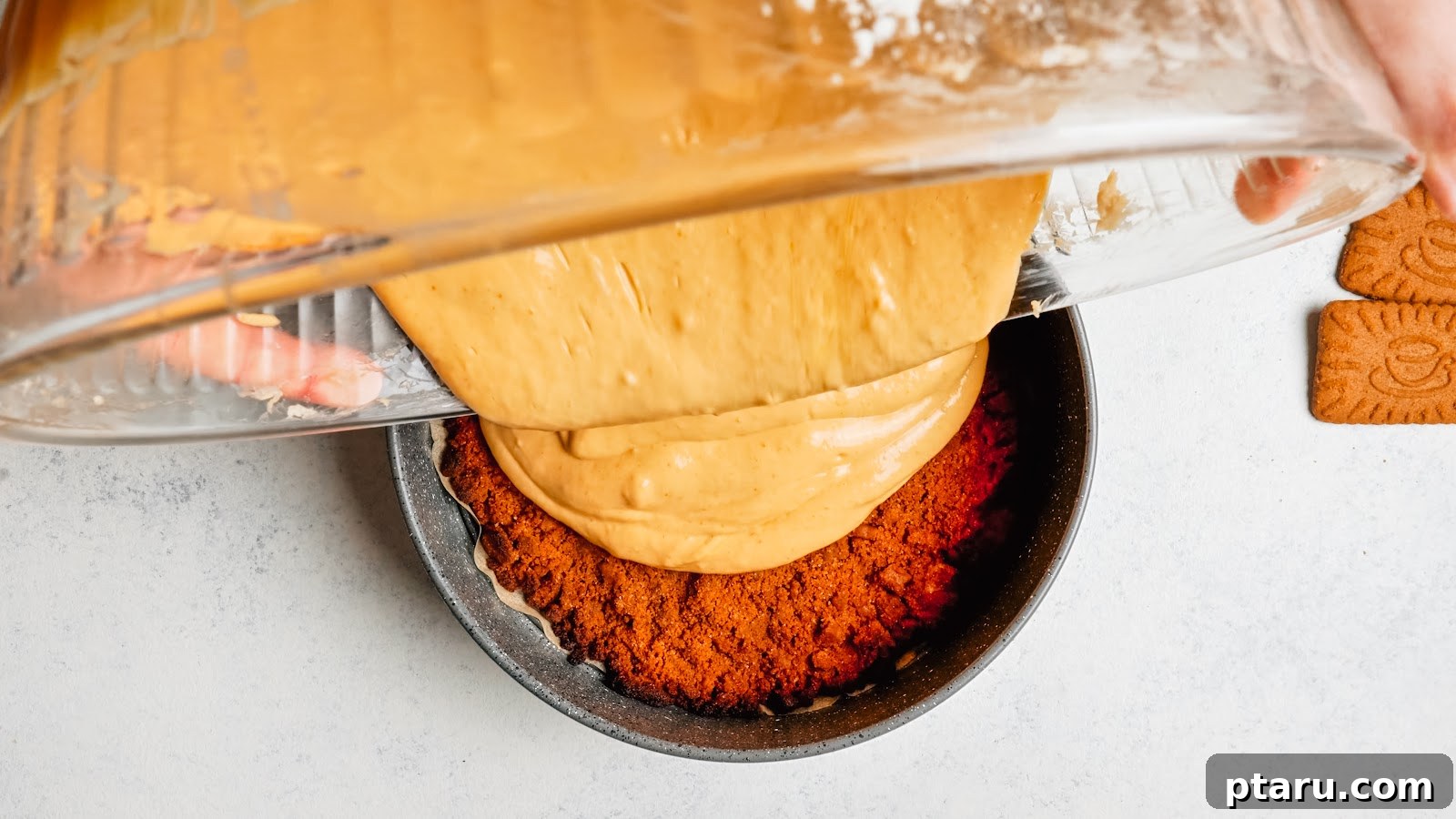 Silky Pumpkin Cheesecake with Gingersnap Crust 10 Pouring pumpkin cheesecake filling over the gingersnap crust.