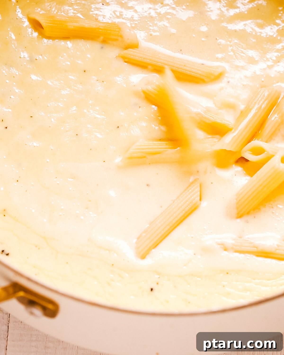 How to Make Garlic Cream Sauce 2 Penne pasta tossed in silky garlic cream sauce in a saucepan.
