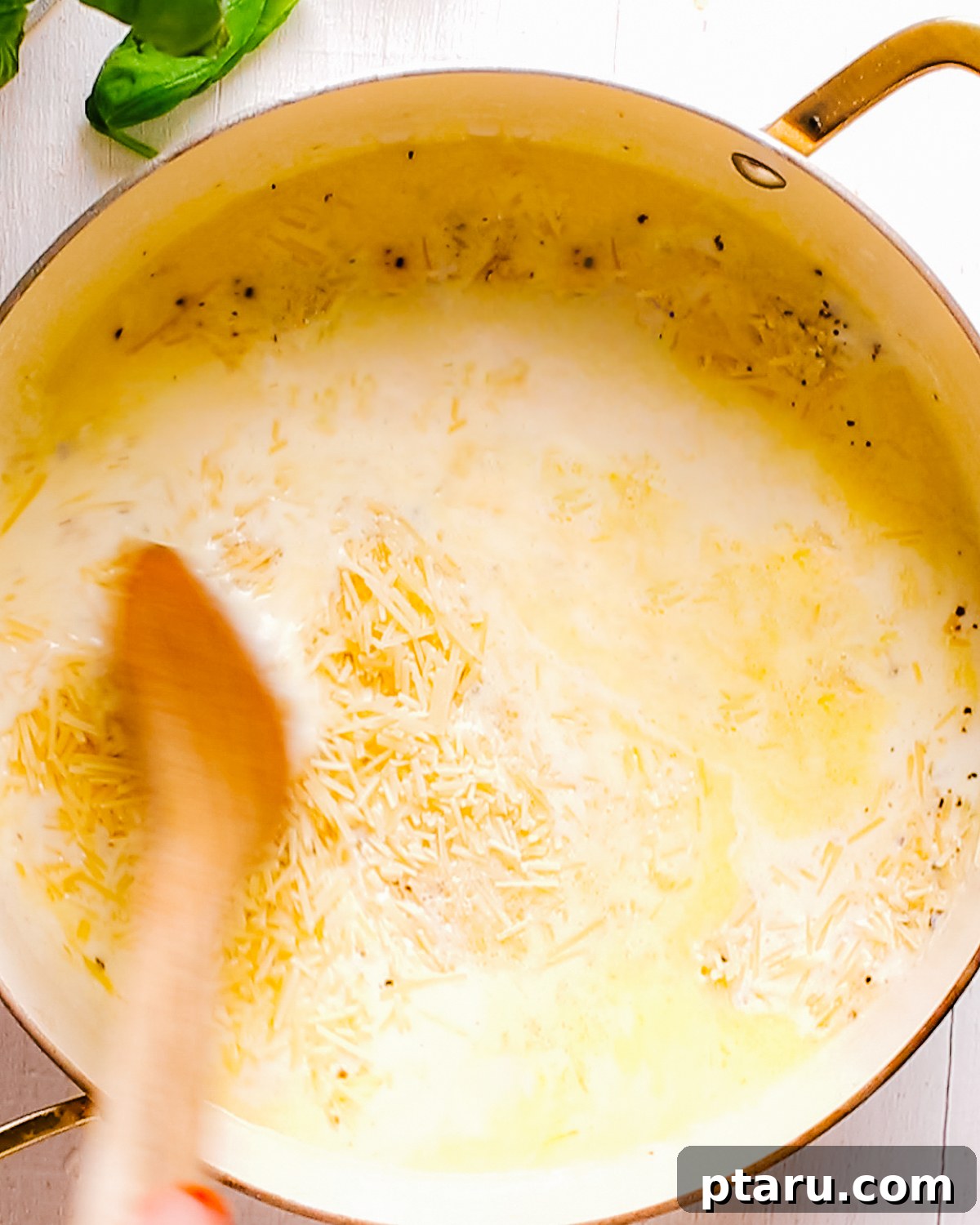 How to Make Garlic Cream Sauce 7 Stirring parmesan into the cream until smooth.